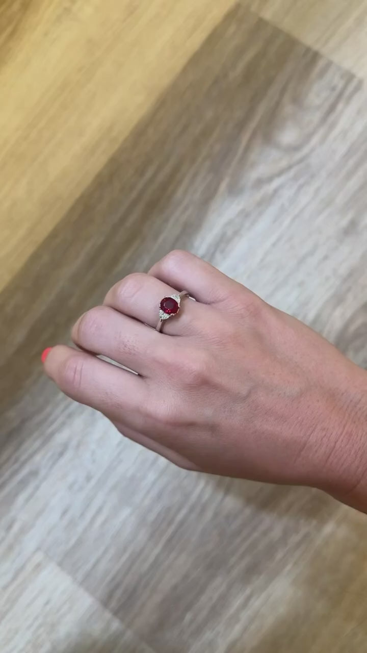 Round ruby ring flanked with diamonds